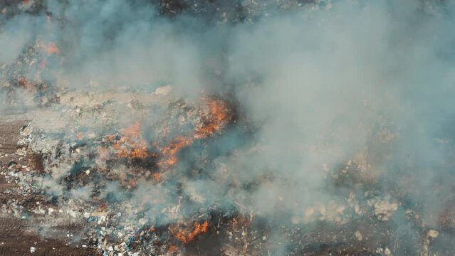 This stock video shows fire and smoke in a garbage dump. This video will decorate your projects related to ecology and fires.