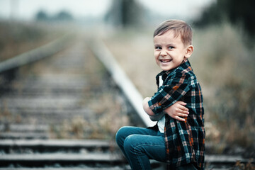 Children's aggression. The child ran away from home. A boy sits on the railway tracks. © SerPak