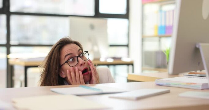 Frightened businesswoman hides in contemporary office