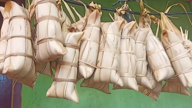 video of traditional indonesian main dish caled lepet a sticky rice dish that covered with coconut leaf