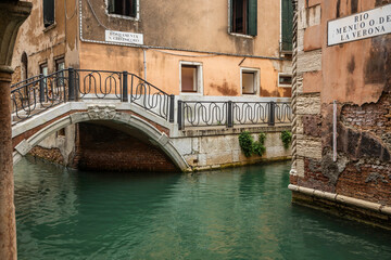 Fototapeta na wymiar A narrow canal bridge in the city of Venice, Italy.