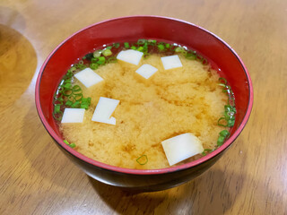 Miso soup (misoshiru) with tofu in a japanese-style soup cup. Miso soup is a traditional Japanese soup which mixed with dashi broth and salted soya bean paste.