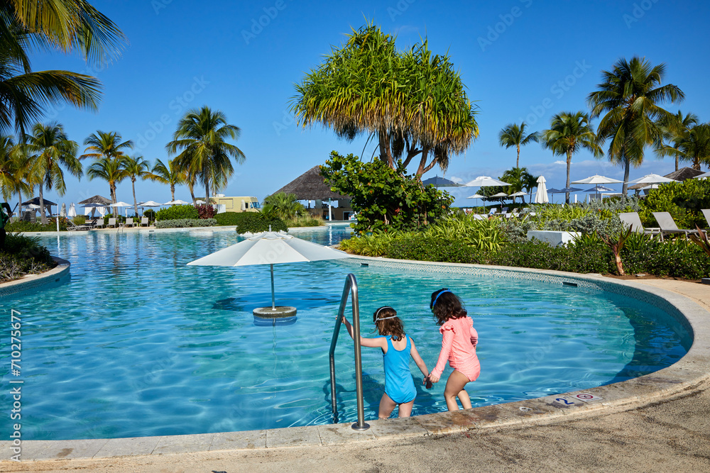 Wall mural first kids into the beautiful pool on day one of their vacation on a sunny and blue sky day - Wall murals