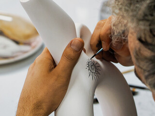 A craftsman paints a pattern on unfired pottery, Türkiye