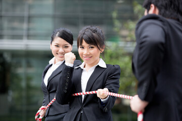 Business people having a tug of war fight.