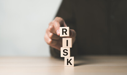 Risk management concept. Businessman hand put risk word on wooden block cube for financial banking analysis and business management. money risk assessment, Reducing project risk, finance, insurance,