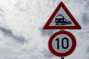 Railroad crossing sign and a 10 kilometers per hour sign