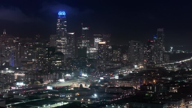 Night traffic aerial panorama 4K drone shot. San Francisco night evening buildings downtown skyline. Skyscrapers finance district. Aerial flight over San Francisco city downtown illuminated at night