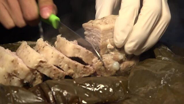 연잎에 쌓여 부드럽게 쪄진 통삼겹살을 작은칼로 먹기좋게 써는 모습