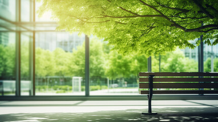 blurred abstract background of bench under tree in green at modern eco office building in sunny day