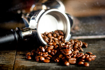Roasted espresso  dark coffee beans in metal holder.