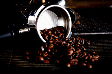 Roasted espresso  dark coffee beans in metal holder.
