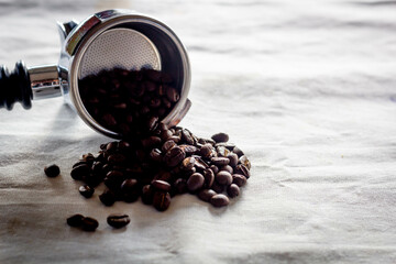 Roasted espresso  dark coffee beans in metal holder.