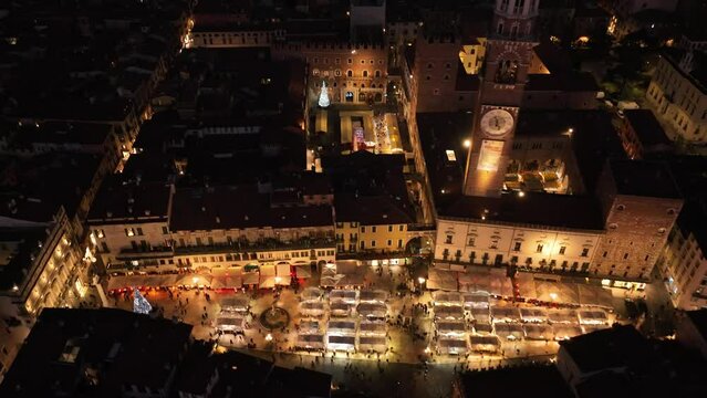 Aerial Backward Rotating Clockwise View of Erbe's Square illuminated at Night - Verona