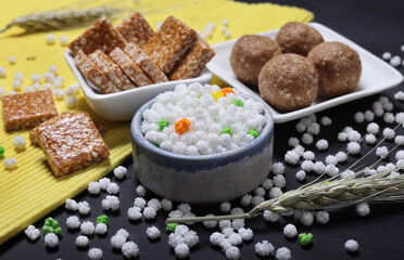 Indian traditional sweets for Makar sankrant festival called Tilgul Laddoo or sesame and Jaggery Laddu Till Tikiya and colourful halwa 