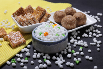 Indian traditional sweets for Makar sankrant festival called Tilgul Laddoo or sesame and Jaggery Laddu Till Tikiya and colourful halwa 