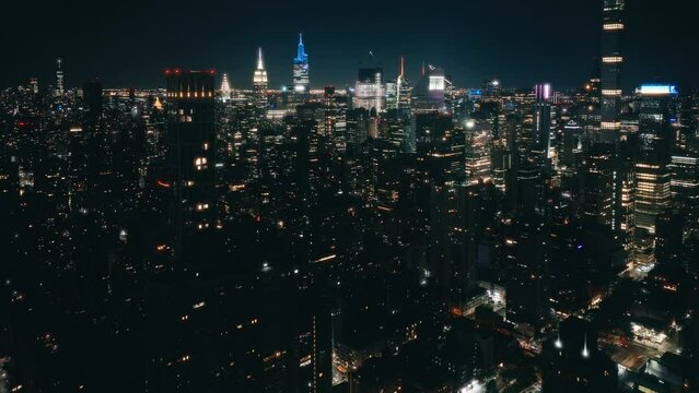 Big Apple cityscape at night drone shot. New York city night evening buildings downtown skyline. Skyscrapers finance district with futuristic views.Aerial flight over NYC downtown illuminated at night