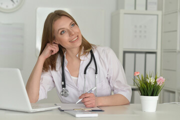 Beautiful girl doctor working at her laptop