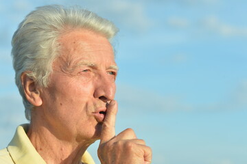 Elderly man put his finger to his lips