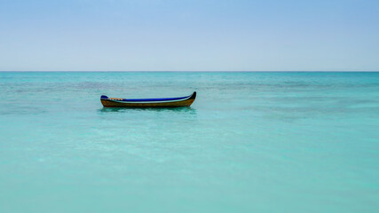 Fototapeta na wymiar Solitary Boat Floating on Calm Turquoise Sea Waters