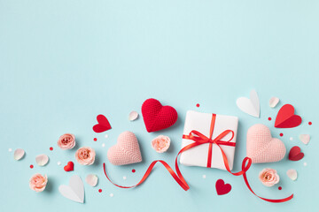 Valentine day or mother day festive composition with gift or present box, rose flowers and red pink hearts on pastel blue background from above. Flat lay style.. - 710297204