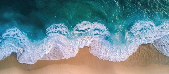 Aerial view of beach with waves washing over wet sand