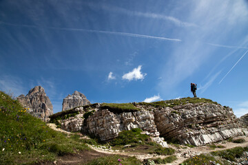 Stunning view of a tourist enjoying the view of the Tre Cime Di Lavaredo, Dolomites, Italy.