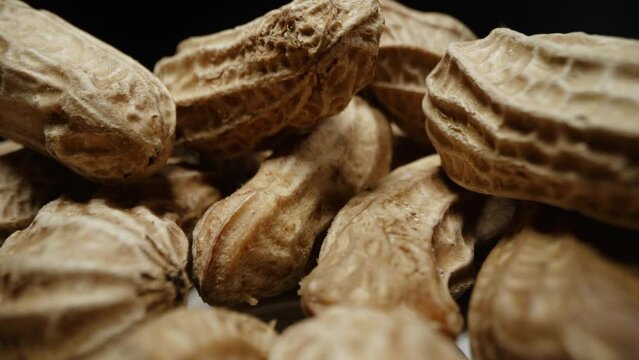 Macro closeup isolate footage of a lot raw peanut or groundnut with peel and unpeel for ingredient