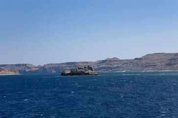 Fototapeta na wymiar Stone island in a bay with rocky shores
