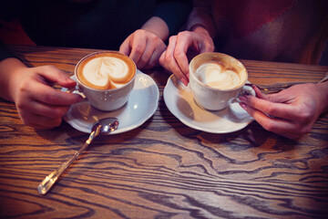 Female friends hands holding cups of coffee