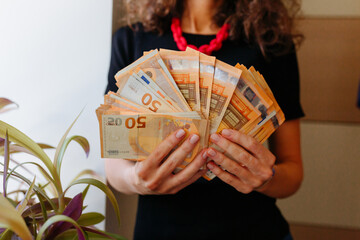 close up of woman hands holding a lot of money