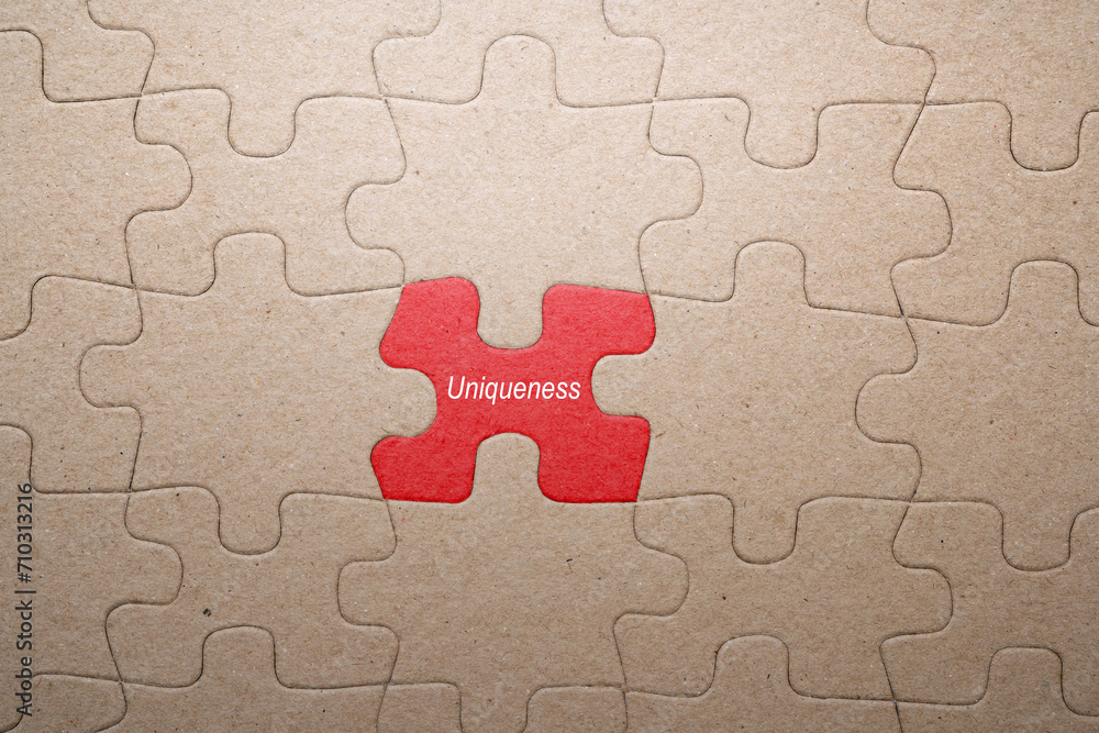 Fototapete Piece of missing jigsaw puzzle with Uniqueness text