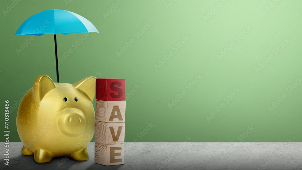 Poster piggy bank with small blue umbrellas above them and wooden cube with save text