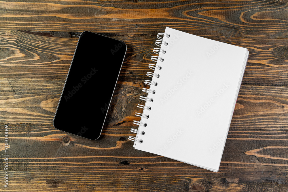 Aufkleber closeup view of mobile phone with blank screen and an empty notebook