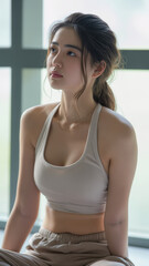 Portrait of young female Korean student in a yoga class looking at the instructor