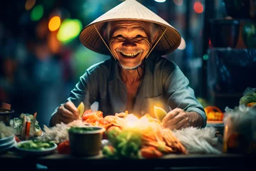 Fotobehang Local man elderly pensioner wearing a traditional hat stands behind his street food stall and smiles. Male street vendor of Thai food at the market. © aapsky