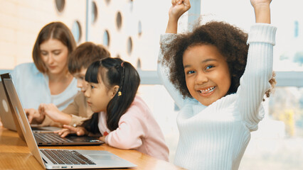 African girl play laptop with diverse friend learning prompt at STEM technology class....