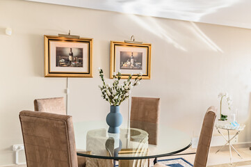 a glass dining table surrounded by art in luxury apartment 