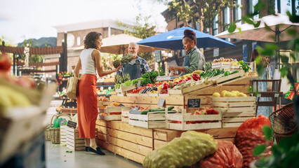 Hispanic Female Customer Buying Two Garlic Heads and a Pineapple From a Multiethnic Farmers Couple. Successful Adults Managing Small Business Farm Stall at a City Square Market
