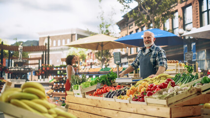 Cheerful Street Vendor Running a Small Farm Market Business, Selling Sustainable Fruits and Vegetables. Happy Middle Aged Man Waiting for Customers in the Morning 