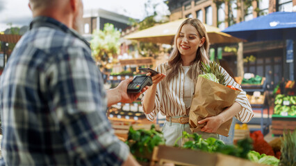 Modern Female Shopper Using Smartphone with Contactless Payment Technology to Pay for Organic...