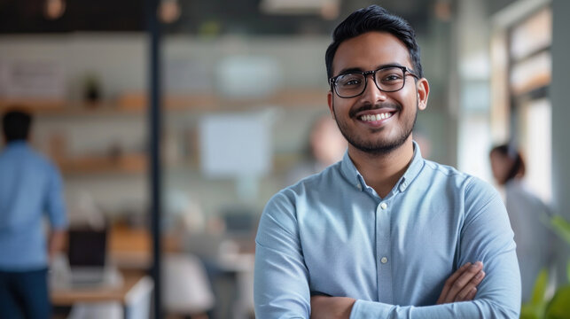 Portrait of a handsome smiling asian indian businessman boss standing in his modern business company office.