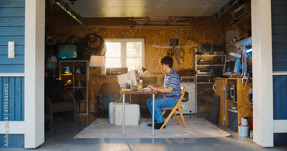 Poster Caucasian Male Software Engineer Programming On Old Desktop Computer In Retro Garage With Random Appliances. Man Working On Innovative Online Service Startup Company In Nineties. Nostalgia Concept.