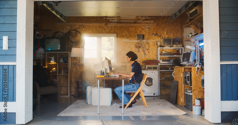 Poster Caucasian Male Software Engineer Programming On Old Desktop Computer In Retro Garage With Random Appliances. Man Working On Innovative Fintech Startup Company In Nineties. Nostalgia Concept.