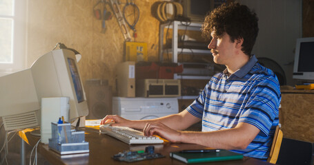 Caucasian Male Software Engineer Programming On Old Desktop Computer In Retro Garage. Enthusiast...
