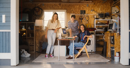 Diverse Team Of Three Young Startup Company Founders In Retro Garage With Old Desktop Computer....