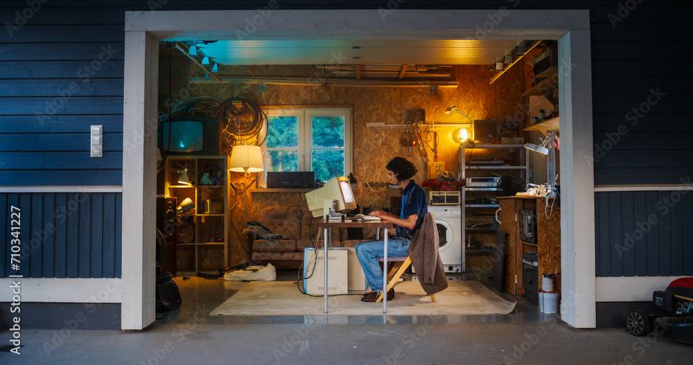 Leinwandbilder caucasian male software engineer programming on old desktop computer in retro garage in the evening.