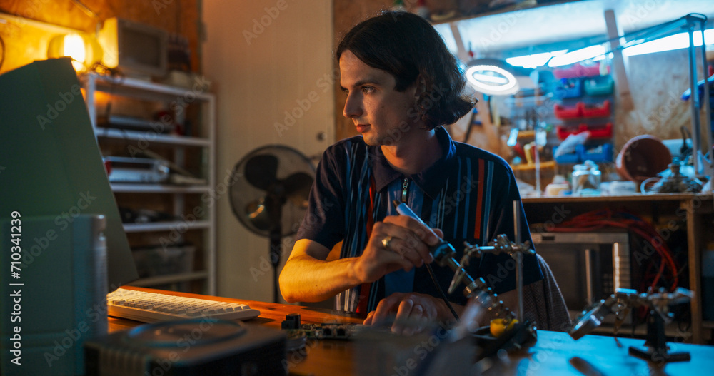 Poster Portrait Of Caucasian Male Software Engineer Programming on Old Desktop Computer In Retro Garage In The Evening. Man Starting Tech Startup Company In Nineties. Coding Innovative Online Service At Home