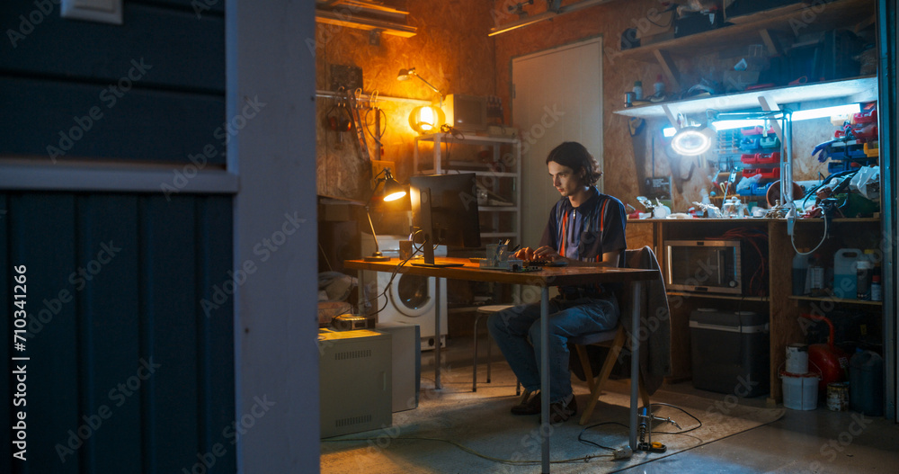 Poster Wide Shot Of Caucasian Male Software Engineer Coding on Old Desktop Computer In Retro Garage In The Evening. Man Starting Tech Startup Company In Nineties. Coding Innovative Online Service At Home.