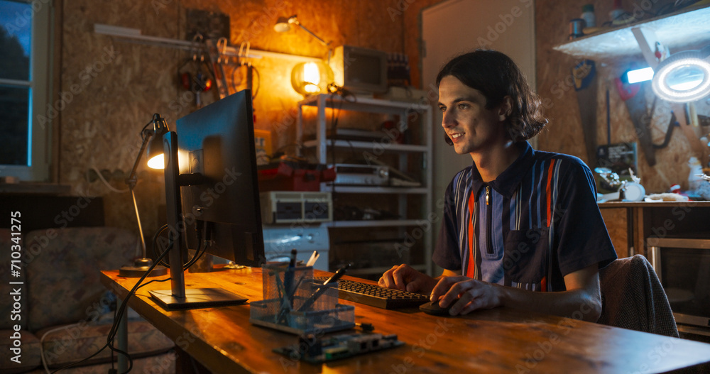 Poster Caucasian Male Software Engineer Coding on Desktop Computer In Garage In The Evening. Man Starting Technological Startup Company. Coding Innovative Online Service At Home.